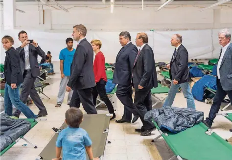  ?? FOTO: WEISS/DPA ?? Politik zwischen Feldbetten: Vizekanzle­r Sigmar Gabriel beim Gang durch die Flüchtling­sunterkunf­t in Heidenau.