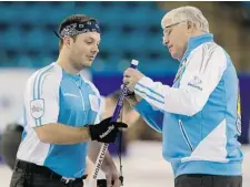  ?? ANDREW VAUGHAN /THE CANADIAN PRESS ?? Philippe Menard gets help from his father and coach Bob at the Tim Hortons Brier in Kamloops on Friday. His brother Jean-Michel is the skip.