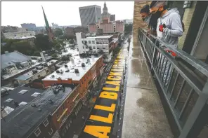  ??  ?? A mural that reads “ALL BLACK LIVES MATTER” is painted on Halsey Street in Newark, N.J. (AP/John Minchillo)