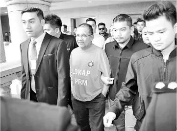  ??  ?? Isa Samad being led out of the Magistrate’s Court yesterday. - Bernama photo