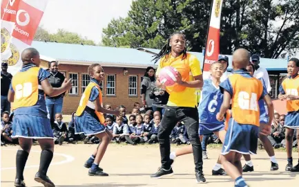  ?? / MDUDUZI NDZINGI ?? Kaizer Chiefs star Siphiwe Tshabalala shares a light moment with kids on the netball court at his former primary school, Phumuzile, in Soweto yesterday. The player also donated playing kit.