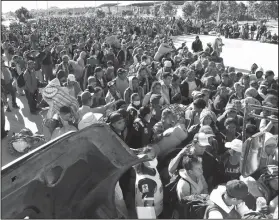  ?? AP Photo/Marco Ugarte ?? Arrival: Migrants traveling with a caravan hoping to reach the U.S. border, wait in line to board buses in La Concha, Mexico, Wednesday. Buses and trucks are carrying some migrants into the state of Sinaloa along the Gulf of California and further northward into the border state of Sonora. The bulk of the main caravan appeared to be about 1,100 miles from the border, but was moving hundreds of miles per day.