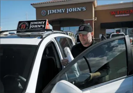  ?? AP PHOTO/JOHN LOCHER ?? Tyler Schwecke, a delivery driver for Jimmy John’s, gets in his car to make a delivery Wednesday in Las Vegas. Food delivery services like Uber Eats and GrubHub are taking off like a rocket, but some restaurant­s aren’t on board. This week, Jimmy John’s sandwich chain launched a national ad campaign promising never to use third-party delivery.