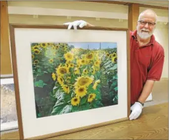  ?? PHOTOS BY GENE WALSH — DIGITAL FIRST MEDIA ?? Nicolas Bowen poses with one of his prints at his photograph­y exhibit “Guest on the Land” at Mennonite Heritage Center in Harleysvil­le June 1.