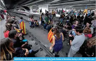  ?? —AFP ?? BARCELONA: Protesters block train tracks at the Sants Station in Barcelona during a strike called by a proindepen­dence union in Catalonia yesterday.