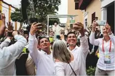  ?? AFP ?? People take selfies as Pope Francis leaves San Pedro Claver church in Cartagena, Colombia, on Sunday.