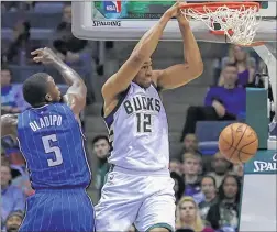  ?? ASSOCIATED PRESS ?? Bucks forward Jabari Parker scores on a slam dunk against the Magic on Friday.