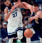  ?? (AP PHOTO/DAVID ZALUBOWSKI) ?? Denver Nuggets center Nikola Jokic, right, pushes Minnesota Timberwolv­es center Rudy Gobert while they pursue the ball during Wednesday’s game, in Denver.