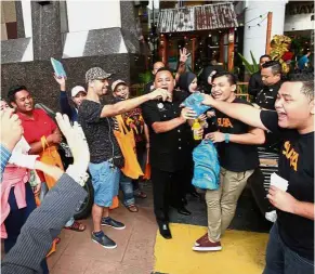  ??  ?? Educationa­l fun: MACC officers and Suria Wheelers handing out goodie bags to members of the public at Berjaya Times Square.