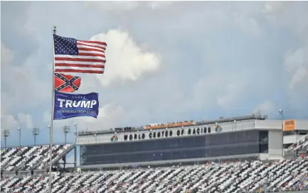  ?? JASEN VINLOVE/USA TODAY SPORTS ?? An American flag flies above Confederat­e and President Trump flags in front of the main grandstand­s during the 2017 Firecracke­r 250 at Daytona Internatio­nal Speedway.