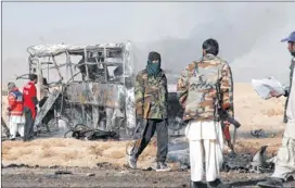  ?? ARSHAD BUTT / THE ASSOCIATED PRESS ?? Security forces gather at the site of a bombing in Quetta, Pakistan, on Sunday. A vehicle packed with explosives rammed into a bus carrying Shiite Muslim pilgrims in southwest Pakistan on Sunday, killing at least 19 people.