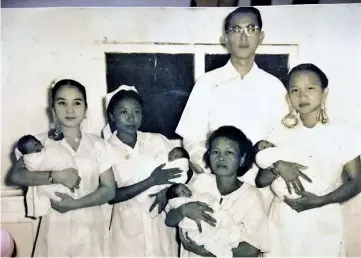  ??  ?? Baun (left) holding one of the four babies she helped deliver during her training in Kuching in 1956.