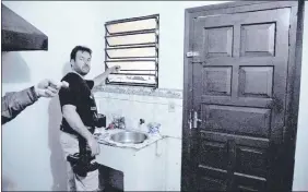  ??  ?? El subcomisar­io Fredy Duarte, de Interpol de Alto Paraná, muestra cómo se parapetó y disparó desde una ventana otro de los delincuent­es.