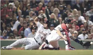  ?? AP ?? Jeimer Candelario, de Detroit, se desliza a salvo en el plato para anotar tras un sencillo de José Iglesias mientras el receptor de los Medias Rojas, Blake Swihart atrapa la pelota en el octavo inning del partido de ayer.