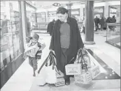  ??  ?? A WOMAN and her child leave after picking up gas mask kits. Israel has relocated missile intercepto­rs.