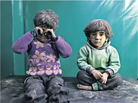  ??  ?? Syrian children are treated at a field hospital after what doctors fear was a chlorine attack on the Hamouriyeh district of Eastern Ghouta in Syria on Monday