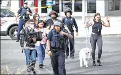  ?? AFP ?? Police escort people fleeing the sceen of a reported shooting near the 2900 block of Van Ness Street in Northwest, Washington, DC, on Friday.