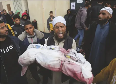  ?? AP PHOTO/ADEL HANA ?? Palestinia­ns chant Islamic slogans while carry the bodies of children killed in the Israeli strikes in the Gaza Strip in front of the morgue at Al Aqsa hospital in Deir al Balah, Gaza Strip, on Sunday.