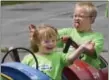  ?? DAILY RECORD / SUNDAY NEWS / PAUL KUEHNEL ?? Campers Aubrey Pace, left, and Jerel Hess, 7, take a ride on a train made of barrels pulled by a John Deere tractor during a Down Syndrome Day Camp.