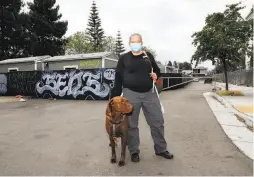  ?? Yalonda M. James / The Chronicle ?? Oakley, 41, and her dog, Fattie, stand outside the Lake Merritt Community Cabins, located on 10th Street in Oakland.