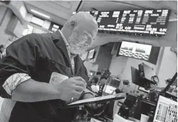  ?? RICHARD DREW AP ?? Trader Vincent Napolitano works on the floor of the New York Stock Exchange on Tuesday as stocks wavered between small gains and losses.