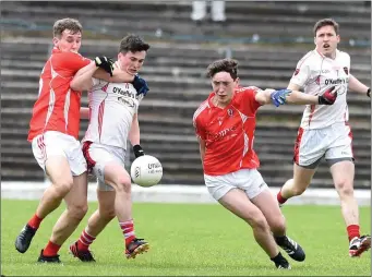  ?? Photo by Michelle Cooper Galvin ?? Rathmore’s Paul Murphy is held by East Kerry’s Dan O’Donoghue while Paudie Clifford gains possession in the County SFC Round 1 in Fitzgerald Stadium.