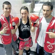  ?? SUBMITTED PHOTO ?? Ali Hayes (centre), flanked by her husband Tory Hayes (left) and Kawartha Combat head coach Kevin Henry, won the World Kickboxing Federation Canadian Muay Thai championsh­ip in the women's 54-kilogram division in Ajax on Sept. 18.