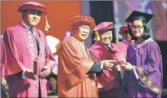  ??  ?? Manyin (second left) presents certificat­e to one of the SLDN graduates. The minister is flanked by Sudarsono on his right and Nidzam.