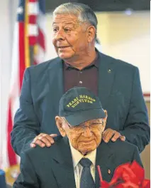  ?? Bob Owen / Staff photograph­er ?? Retired Major Gen. Alfred Valenzuela, with Pearl Harbor survivor Radioman 1st Class William St. John, addresses a gathering of Pearl Harbor family members at the Barn Door on Friday.