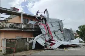  ?? SOLOFO RASOLOFOMA­NANA — THE ASSOCIATED PRESS ?? People work on a damaged building, in Mananjary district, Madagascar, Wednesday after cyclone Freddy reached Madagascar.