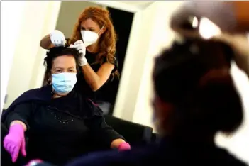  ?? MATTHIAS SCHRADER
AP PHOTO/ ?? A young hairdresse­r and a customer wearing face masks and gloves to protect against the coronaviru­s in a salon in Brixen, Italy, Monday.