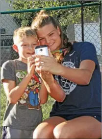  ?? CHRIS BARBER — DIGITAL FIRST MEDIA ?? Cierra Runge shares a selfie with Asher Smith, 9, of Oxford, at the YMCA reception after her return home from the Olympics.