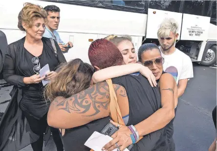  ??  ?? Students from Marjory Stoneman Douglas High School and community members hug before students board buses in Parkland, Fla., to head to the state capital to meet with lawmakers about gun violence. CRISTOBAL HERRERA/EPA-EFE