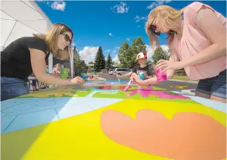  ?? GAVIN YOUNG ?? Silver Springs residents help artist Dean Stanton paint 24 panels which will form a mural on the newly renovated Silvers Springs pool building. The work began on Sunday and continues until Tuesday.