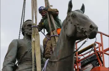  ?? Steve Helber/Associated Press ?? Work crews remove the statue of Confederat­e Gen. Stonewall Jackson on July 1 in Richmond, Va. As officials in larger cities act to remove Confederat­e statues, those in smaller, rural areas are either voting against removals or moving more slowly in the process of removing them.