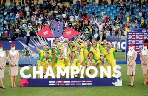  ?? Reuters ?? ↑
Australian­s pose with the trophy after winning the T20 World Cup final match against New Zealand at the Dubai Internatio­nal Cricket Stadium on Sunday.