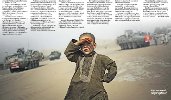  ??  ?? A boy looks on as US vehicles drive past his village in Afghanista­n.