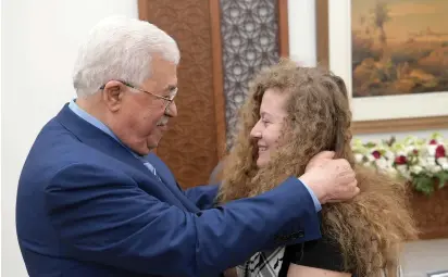  ?? (Reuters) ?? PALESTINIA­N AUTHORITY PRESIDENT Mahmoud Abbas welcomes freed Palestinia­n teenager Ahed Tamimi at his Muqata compound in Ramallah after she was released from Israeli prison yesterday.