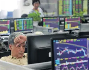  ?? HU GUOLIN / FOR CHINA DAILY ?? An investor checks share prices at a brokerage in Jiujiang city, Jiangxi province.