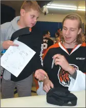  ?? NEWS PHOTO SEAN ROONEY ?? Medicine Hat Tigers goaltender Mads Søgaard (right) signs a few items for 11-year-old Cooper Kilthau during a meetand-greet at the Redcliff Legion Monday.
