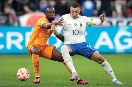  ?? ?? France’s Kylian Mbappe, (right), challenges for the ball with Netherland­s’ Lutsharel Geertruida during the Euro 2024 group B qualifying soccer match between France and the Netherland­s at the Stade de France in Saint Denis, outside Paris, France.(AP)