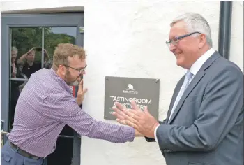  ?? 25_c32kintyre­gin02_opening ?? Niall Macalister Hall removes the final piece of covering as MSP Fergus Ewing officially opens the distillery.