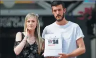  ?? PETER NICHOLLS / REUTERS ?? The parents of critically ill baby Charlie Gard, Connie Yates and Chris Gard, pose with a petition outside a hospital in London on Sunday.