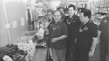  ??  ?? Henry weighing a bag of flour to see if the scale was in order, during a visit to a KPDNKK POS in Bario as others look on.