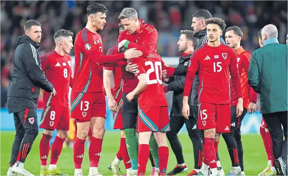  ?? ?? DEVASTATIO­N: Wales’ Dan James is consoled by his team-mates after missing the decisive spot-kick during the penalty shoot-out.