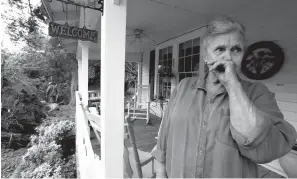  ?? Associated Press ?? ■ Sandra Cotten of Flora, Miss., chokes up Sunday after looking at her uprooted 100-year-old oak tree that now lies across her yard and two streets. Cotten recalled hearing a loud "swosh" as the massive oak fell next to her house in Saturday's severe weather. The Flora native lamented the tree's loss for the summer shade it provided. The storm was one of several that hit the state.