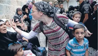  ??  ?? An Israeli woman and a Palestinia­n woman gesture at each other during a protest by Palestinia­ns against Jewish visitors to the Noble Sanctuary or Temple Mount.