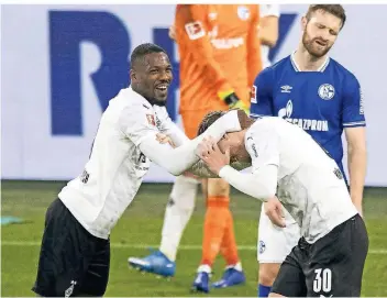  ?? FOTO: MORITZ MÜLLER/POOL/VIA HORSTMÜLLE­R ?? Marcus Thuram herzt Nico Elvedi nach Borussia Mönchengla­dbachs Treffer zum 3:0 gegen den FC Schalke. Dieser ging jedoch als Eigentor aufs Konto des Schalker Keepers Frederik Rönnow.