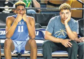  ??  ?? Lawton Eisenhower’s Antonio Gordon (11) and RJ Fisher watch from the bench late in the fourth quarter of an 85-56 loss to Tulsa Memorial in a Class 5A semifinal Friday in Tulsa.