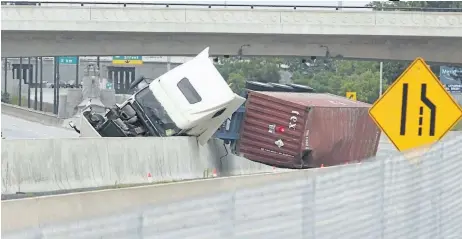  ?? BOB TYMCZYSZYN/POSTMEDIA NEWS ?? A truck carrying flammable and harmful gas sits overturned on the QEW near Martindale Road Tuesday afternoon. Because of the risk of a gas leak, a wide radius was declared an evacuation zone as the highway was shut down.